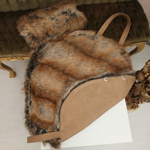 Pu&ograve; includere: Una borsa tote in pelliccia sintetica marrone con fondo e manici in pelle marrone. La borsa ha una forma rotonda ed &egrave; realizzata in pelliccia sintetica morbida e soffice.