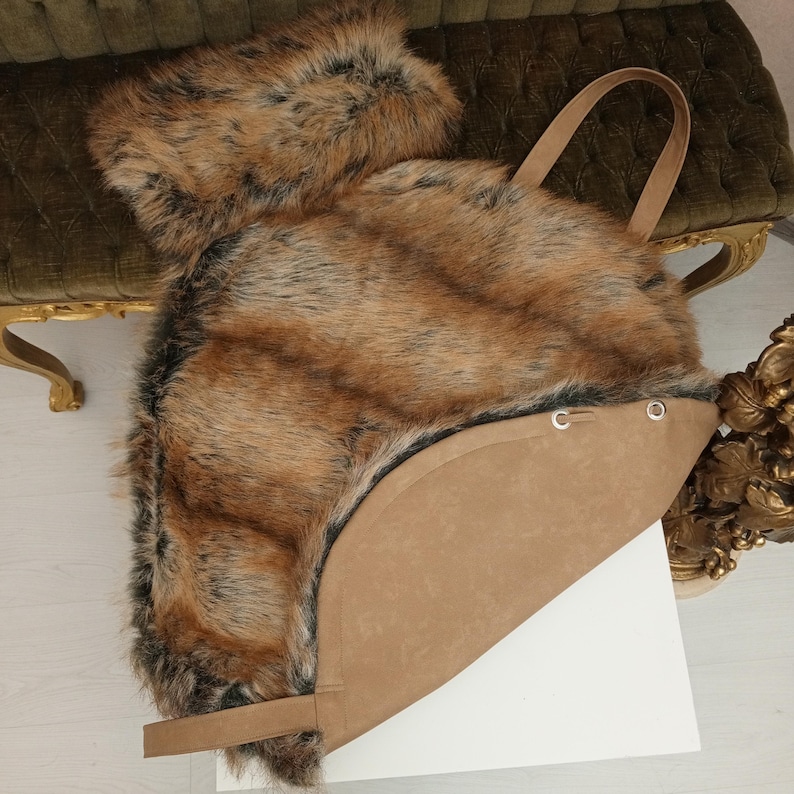 Pu&ograve; includere: Una borsa tote in pelliccia sintetica marrone con fondo e manici in pelle marrone. La borsa ha una forma rotonda ed &egrave; realizzata in pelliccia sintetica morbida e soffice.