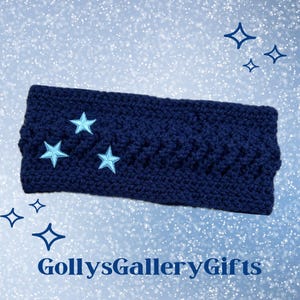 May include: A navy blue crocheted headband featuring three light blue embroidered stars. The headband has a textured design and is set against a light blue, sparkling background. The text "GollysGalleryGifts" is visible at the bottom.