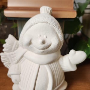 Ceramic smiling and waving snowman, ready for you to paint. Unpainted bisque snowman.