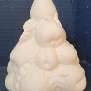 May include: White ceramic sculpture of a fruit arrangement. The sculpture features a pear, apples, and grapes. The sculpture is designed to look like a pile of fruit.