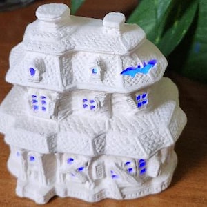Ceramic miniature haunted house ready to paint. Cut out windows and cut out bat on roof. Light up Halloween decoration.