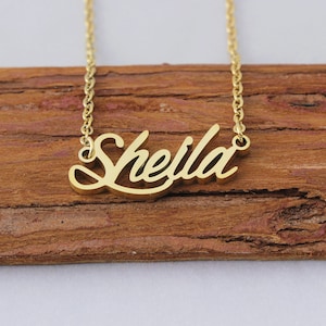 May include: A gold necklace with the name "Sheila" spelled out in a cursive font.