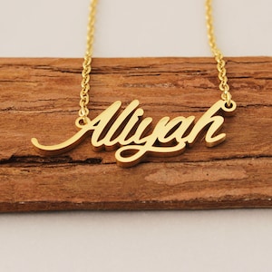 May include: A gold-tone necklace with the name "Aliyah" spelled out in a cursive font.
