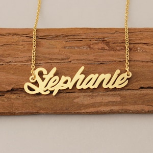 May include: Gold necklace with the name "Stephanie" spelled out in a cursive font.