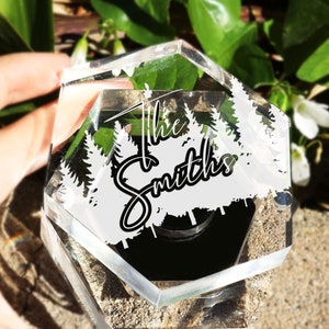 May include: A clear hexagonal box with a black base and a white silhouette of trees and the text "The Smiths" engraved on the side.