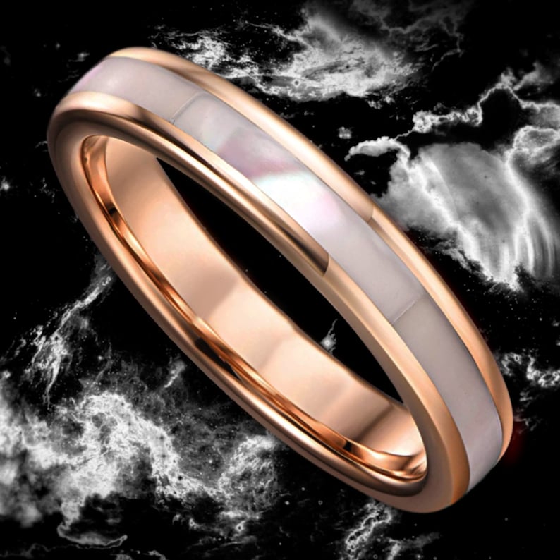 May include: A rose gold wedding band with a white mother-of-pearl inlay.