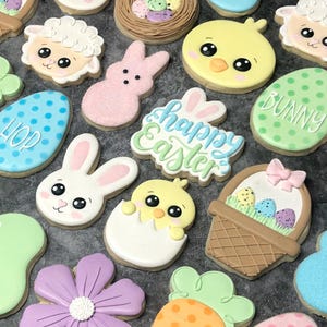 May include: A collection of Easter-themed sugar cookies decorated with various designs, including bunnies, chicks, eggs, flowers, and a basket of eggs. The cookies are decorated with pastel colors and have intricate details.