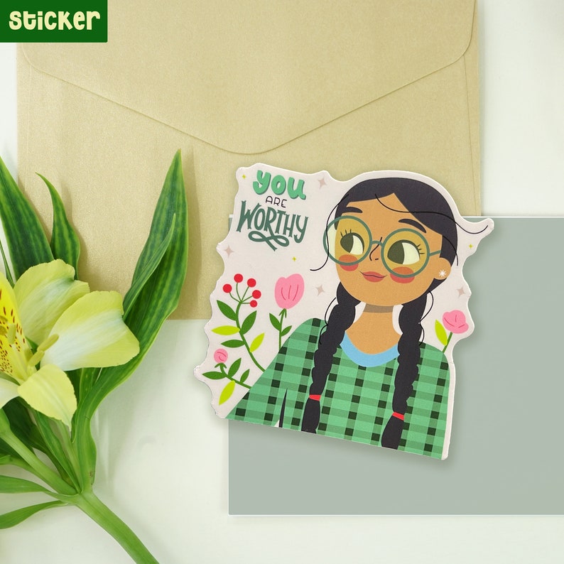Peut inclure: Un autocollant avec une illustration de dessin anim&eacute; d'une personne avec de longues tresses noires portant des lunettes et une chemise &agrave; carreaux vert et blanc. Le texte "You are worthy" est &eacute;crit dans une police de caract&egrave;res fantaisiste sur un fond rose.