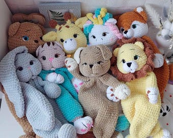 May include: A collection of crocheted stuffed animals, including a giraffe, a unicorn, a lion, a bunny, a cat, and a dog. The animals are all different colors and have different facial expressions.