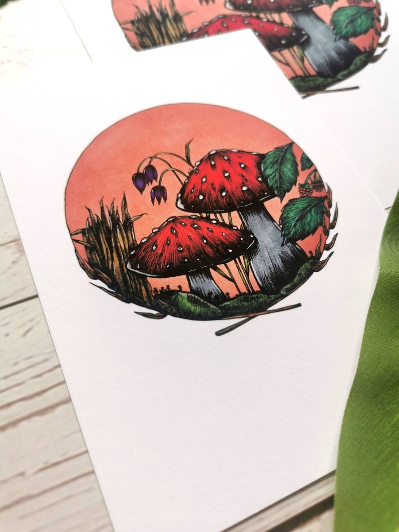 May include: A watercolor illustration of two red and white mushrooms with white spots in a forest setting. The mushrooms are surrounded by green leaves, tall grass, and a pink and orange sunset.