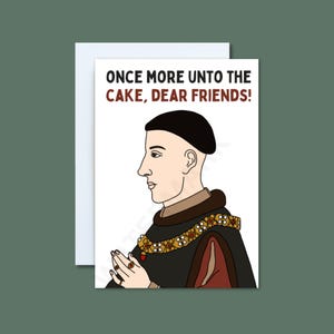 May include: Greeting card with a cartoon illustration of a historical figure in profile, wearing a black hat and ornate clothing. The card includes the text "ONCE MORE UNTO THE CAKE, DEAR FRIENDS!" in brown letters.