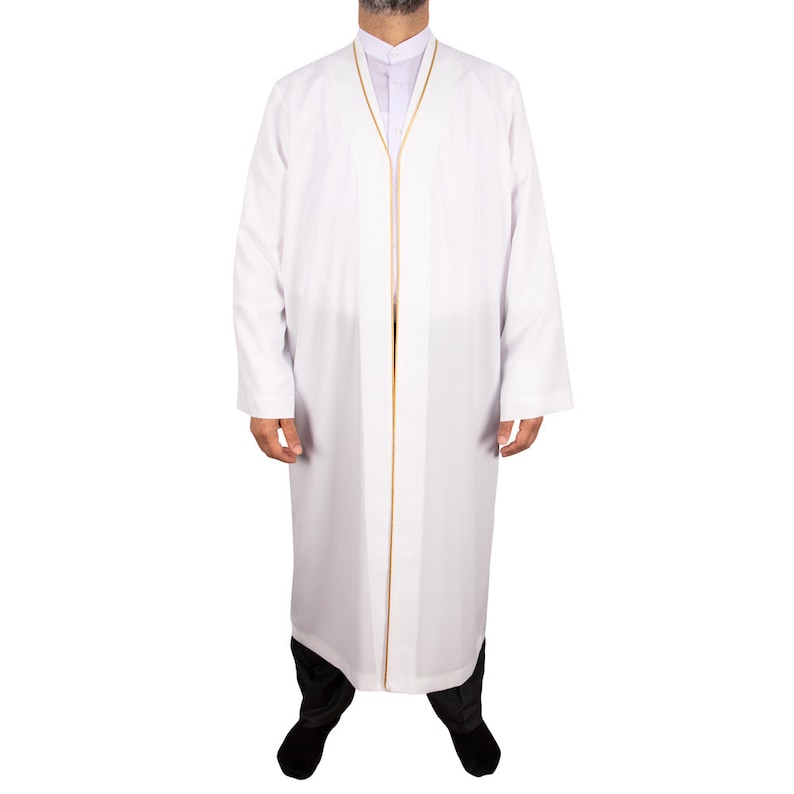 Puede incluir: Thawb blanco con ribete dorado. La prenda de manga larga presenta un cuello mandar&iacute;n y un dise&ntilde;o de cuerpo entero. El thawb se combina con pantalones negros y zapatos negros. La prenda est&aacute; hecha de una tela ligera.