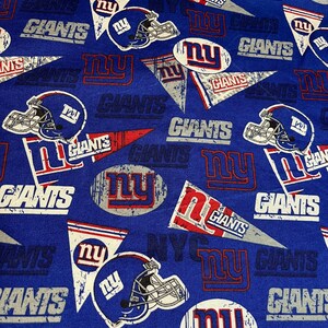 May include: Blue fabric with a repeating pattern of the New York Giants logo. The logo features the team's name, "Giants", and the letters "NY" in a circle. The fabric also includes the team's helmet.