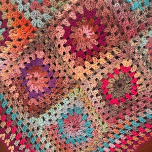 Crocheted blanket , deep jewel colours , blues , pinks ,oranges, greens, reds and greys. Handmade by myself wool and acrylic yarn.