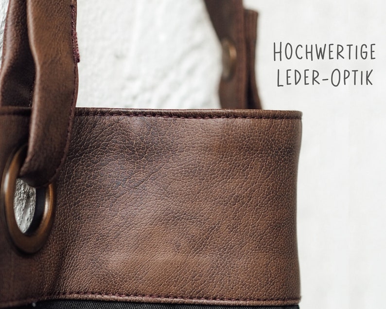 May include: Close-up of a brown tote bag with a textured leather-like appearance. The bag has dark brown handles and a metal ring detail. The text "HOCHWERTIGE LEDER-OPTIK" is visible on the right side.