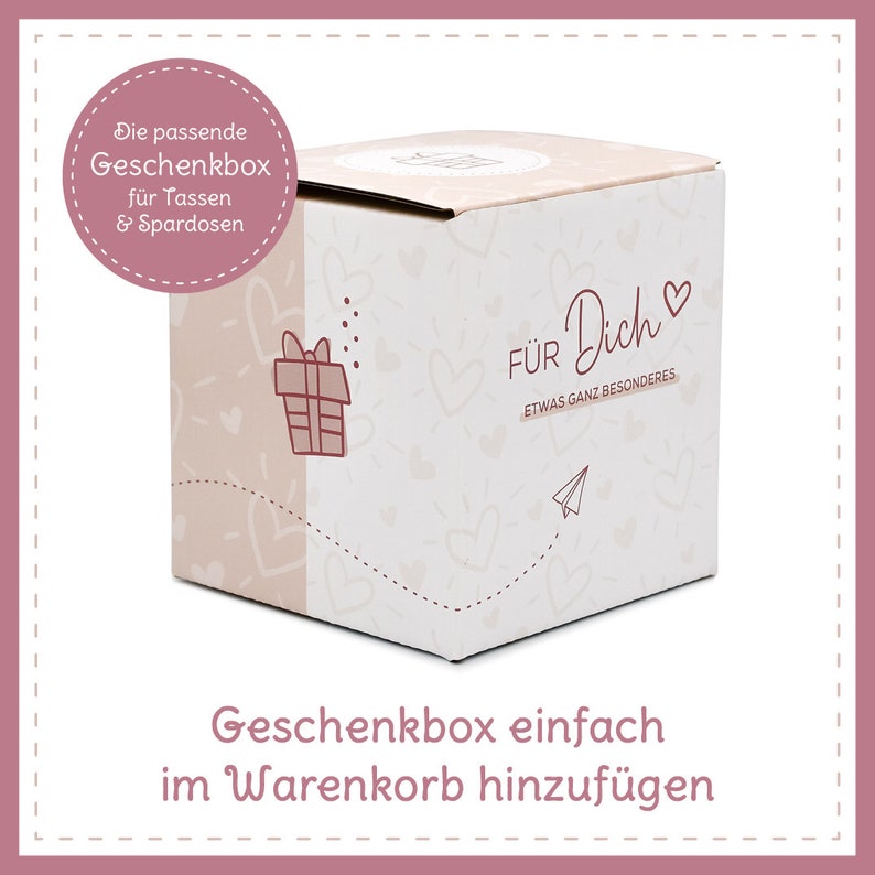 May include: A square gift box with a light pink and white design. The box has the words "F&Uuml;R Dich" and "ETWAS GANZ BESONDERES" printed on it, along with a gift icon, hearts, and a paper airplane. The text "Die passende Geschenkbox f&uuml;r Tassen & Spardosen" is also visible.