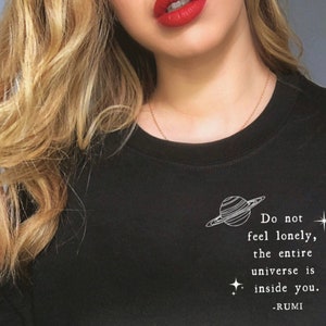 May include: Black sweatshirt with a white graphic of a planet and the text "Do not feel lonely, the entire universe is inside you. -RUMI"