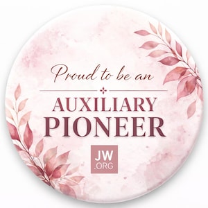 May include: A round, pink and white button with the text "Proud to be an AUXILIARY PIONEER." The design includes watercolor-style pink leaves and the JW.ORG logo. The text is in a dark burgundy color.