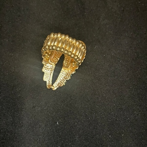 K&ouml;nnte beinhalten: Ein goldener Ring mit einem strukturierten Design. Der Ring besteht aus kleinen, runden Perlen, die miteinander verbunden sind.