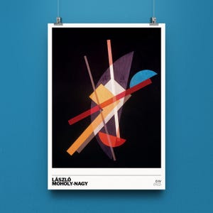 May include: A framed art print featuring an abstract composition by László Moholy-Nagy. The artwork, titled DIV (1922), showcases geometric shapes in red, orange, yellow, white, and purple against a black background. The print is displayed on a blue wall.