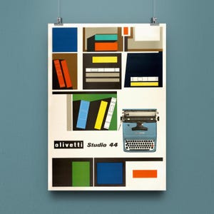Op de afbeelding: Een vintage Olivetti Studio 44 poster met een blauwe typemachine en kleurrijke geometrische vormen. De poster, met de tekst "olivetti Studio 44", wordt gepresenteerd tegen een blauwe achtergrond.