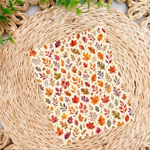 May include: A rectangular card featuring a repeating pattern of autumn leaves in shades of red, orange, yellow, and brown against a cream background. The leaves vary in shape and size, depicting maple, oak, and other foliage types in a dense arrangement.