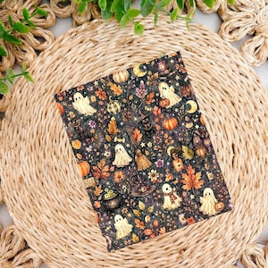 May include: A rectangular sheet featuring a dark gray background with a repeating pattern of white ghosts, orange pumpkins, black cats, witch hats, brooms, potions, and autumn leaves in shades of yellow, orange, and brown, with small stars.
