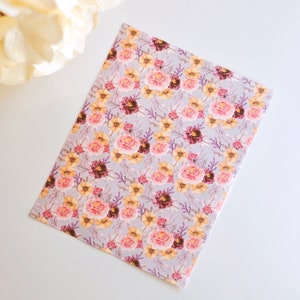 Puede incluir: Una tarjeta de felicitación rectangular con un denso estampado floral sobre un fondo gris claro. El diseño incluye racimos de rosas rosadas, flores amarillas y flores de color burdeos oscuro intercaladas con finas ramas moradas.