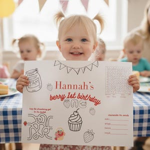 May include: A white rectangular activity sheet featuring the text Hannah's berry 1st birthday, a cupcake illustration, a jam jar, strawberries, a word search, a maze, and an unscramble the words game, all printed in black and red ink.