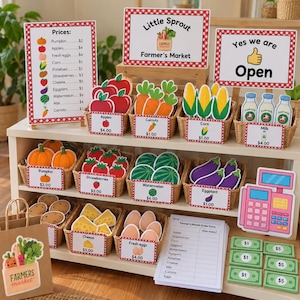 May include: A pretend play farmer's market set featuring cardboard food items in woven baskets, price signs, a cash register, play money, and an order form. Signs include text like Little Sprout Farmer's Market, Yes we are Open, and a price list.