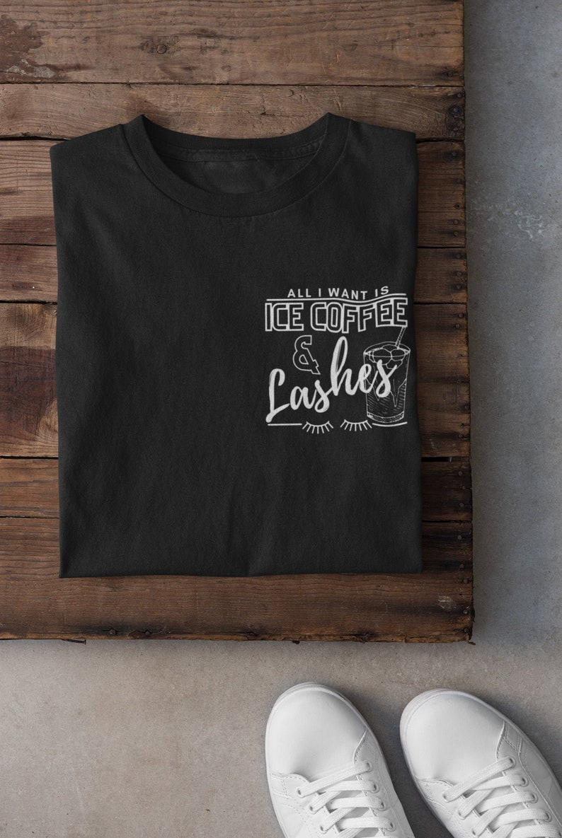 May include: Black t-shirt with white text that reads "All I want is Ice Coffee & Lashes" with a drawing of a glass of iced coffee and eyelashes.