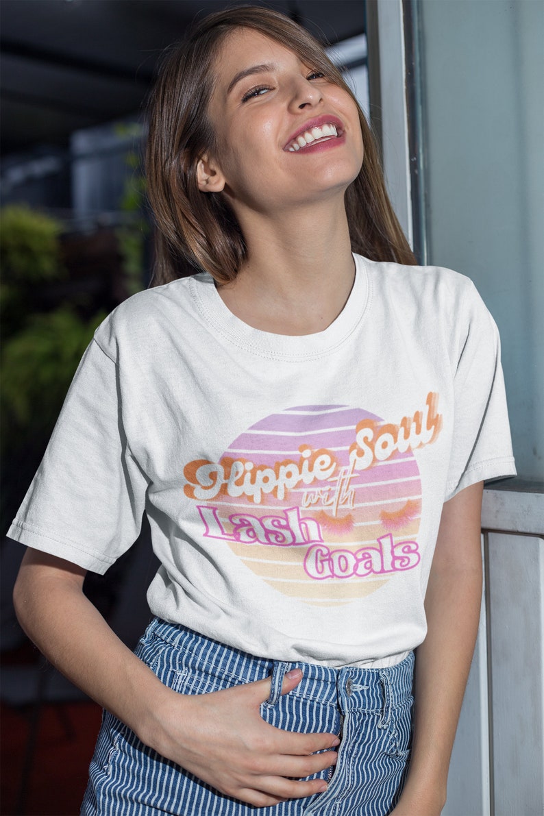 Puede incluir: Camiseta blanca con un gr&aacute;fico rosa y naranja que dice "Hippie Soul with Lash Goals".