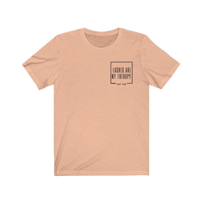 May include: A peach coloured t-shirt with the text "Lashes are my therapy" in a black box with eyelashes underneath.