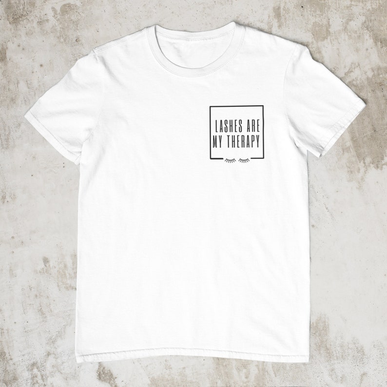 May include: White t-shirt with a black square graphic that says "Lashes are my therapy" with a pair of eyelashes underneath.