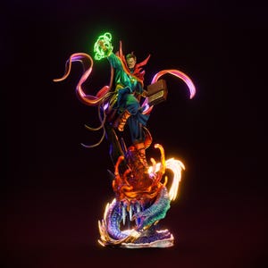 May include: A detailed figurine of Doctor Strange, in a dynamic pose, with a green energy sphere in his hand. He wears a blue and green costume with a red cape. The base features a dragon with flames and a dark background.