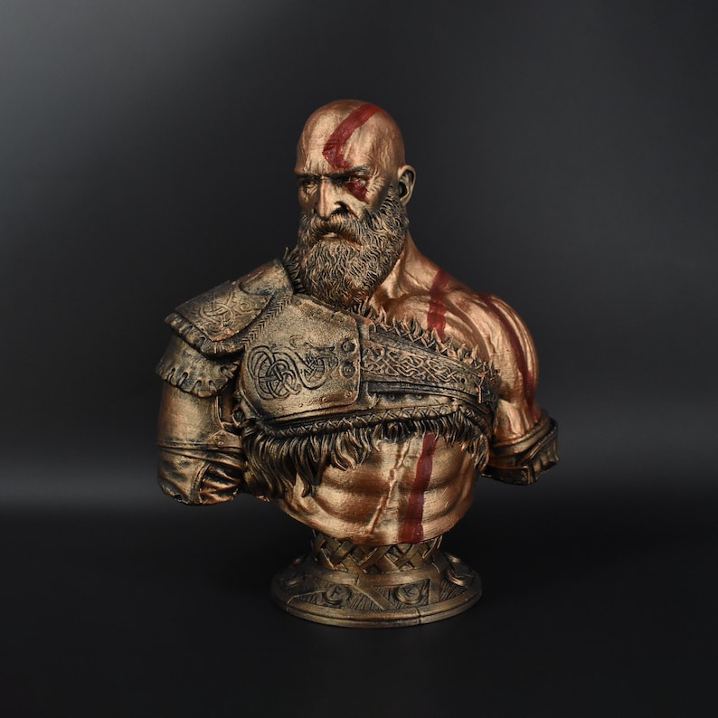 Puede incluir: Un busto de bronce de un hombre calvo y barbudo con marcas rojas en la cara y el pecho. Lleva una armadura detallada y adornada con un ribete de plumas. El busto est&aacute; sobre un pedestal con una superficie texturizada.