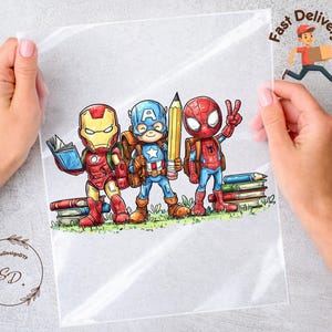 May include: A clear plastic sheet featuring a colorful cartoon illustration of Iron Man, Captain America, and Spider-Man as students. The characters are depicted with backpacks, books, and a large yellow pencil, standing on a patch of green grass.
