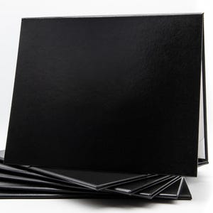 May include: A stack of black presentation folders with a glossy finish. One folder is propped up, revealing a white interior. The folders are arranged on a white background, creating a clean and professional look.