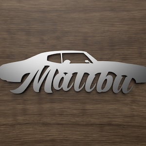 Könnte beinhalten: Eine silberne Metallsilhouette eines klassischen Autos mit dem Wort "Malibu" in einer stilisierten Schrift darunter.
