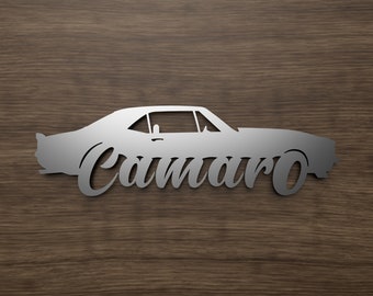 Może przedstawiać: Srebrna metalowa sylwetka klasycznego samochodu Camaro z napisem "Camaro" napisanym stylizowanym fontem pod samochodem.