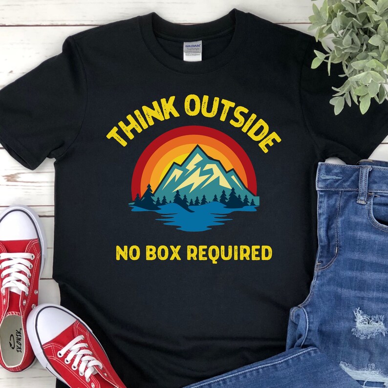 May include: Black t-shirt with a retro-style mountain scene and the text "Think Outside No Box Required".