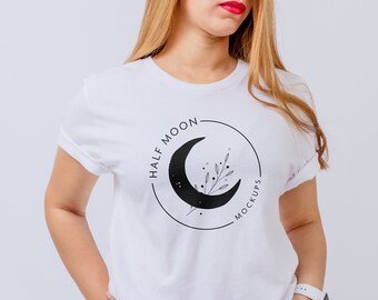 May include: A white short-sleeved t-shirt featuring a black circular graphic on the chest. The design includes a crescent moon, a delicate botanical sprig, and the text "HALF MOON MOCKUPS" written in a clean, sans-serif font along the circle's edge.