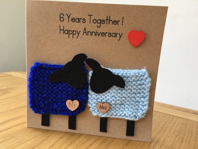 May include: A handmade card with a blue and light blue knitted sheep design. The card says "6 Years Together! Happy Anniversary" and has a red heart.
