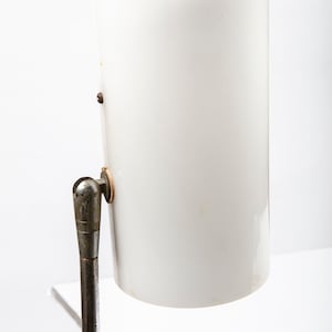 Mid century modern style standing floor lamp with white polycarbonate shade.