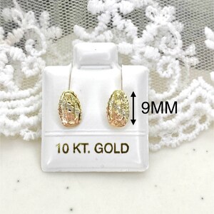Op de afbeelding: Goudkleurige oorstekers met een gedetailleerd ontwerp, gepresenteerd op een witte standaard. De oorbellen zijn ongeveer 9 mm groot. De standaard is gemarkeerd met '10 KT. GOLD'.