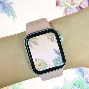 May include: A pink Apple Watch with a floral watch face. The watch face shows the time as 1:57 and the day as SAT 7. The watch face also shows the temperature as 90 degrees and the weather as sunny.