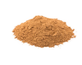 May include: A pile of light brown cinnamon powder on a white background.
