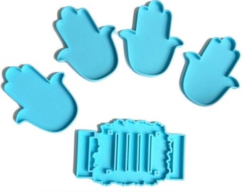 May include: Set of four blue silicone molds shaped like the Hamsa hand, a symbol of protection, and a separate blue silicone mold shaped like a wreath with five vertical lines inside.