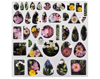May include: A sheet of clear resin with various shapes and sizes of pressed flowers. The flowers are in shades of pink, white, yellow, and green. The resin is clear and allows the flowers to be seen clearly.